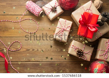 Christmas background with gift boxes wraped in craft paper over wooden table prepared for celebrating festive holiday season. Copy space. Top view.
