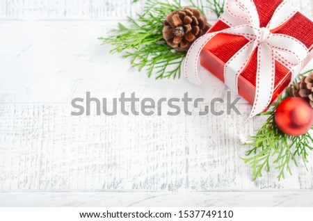 Christmas background with red gift box on a white wooden background. Winter festive concept. Selective focus, copy space.