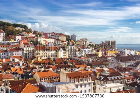 Lisbon cityscape, view of the old town Alfama, Portugal, panorama.Lisboa colorful houses and red-tiled roofs. Hills with trees and historical buildings on a sunny day. Rooftops of the Portuguese city.