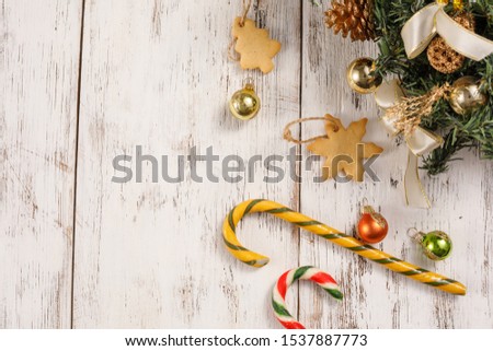 Christmas caramel canes and cookies on an aged white wooden background. Happy new year background, composition of christmas decorations. Holiday concept. Flat lay.