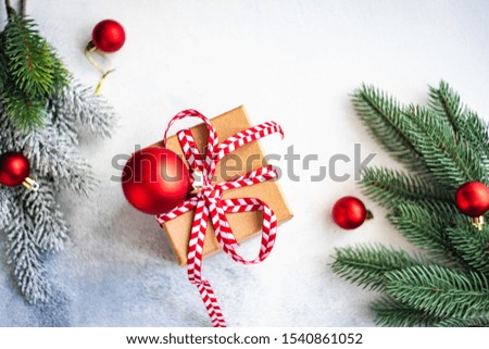 Christmas frame with gift box, holiday decor and fir tree on white stone background with copy space