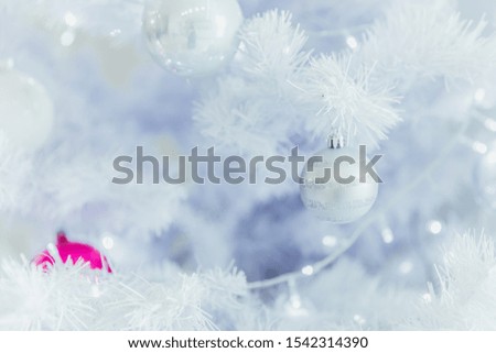 Close up of a Christmas ball in a white fir tree with lights background