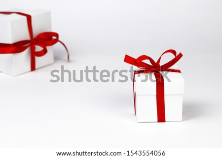 Gift boxes. Big and small white gift boxes with red ribbon light background. Part of set.