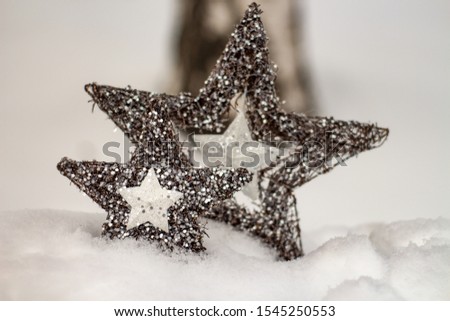 star ornaments in the snow; christmas card with bokeh background