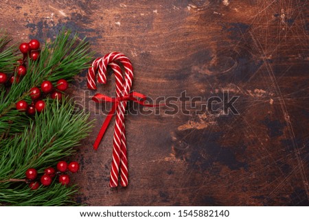 Candy canes with fir tree branches on wooden background. Christmas composition. New Year concept. Top view - Image