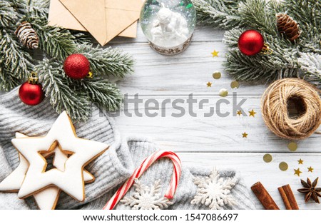 Christmas Tree Pine Branches with decorations  and gingerbread cookies  on a wooden table. Holiday background with copyspace. Top view
