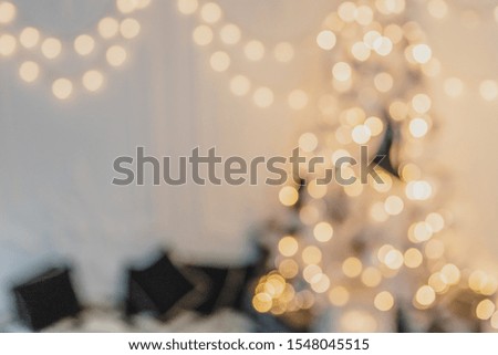 Gold defocused christmas garland and fir with baubles and ribbons on white.