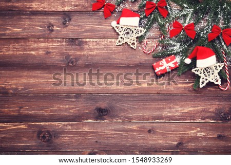 Christmas tree branches with toys and candies on brown wooden table