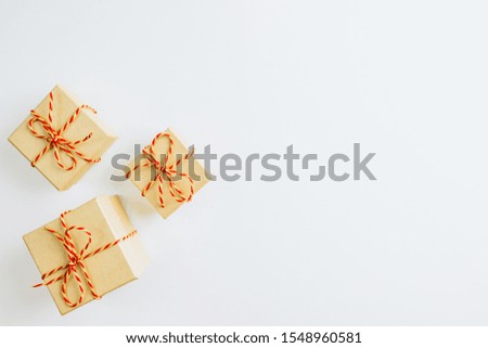 Christmas composition. Christmas gift boxes in craft paper on white background. Top view, flat lay, copy space. Christmas or New Year minimal concept.