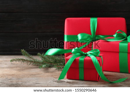 Christmas gifts on wooden table against dark background. Space for text