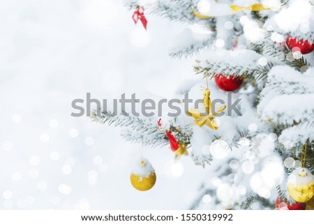 Christmas tree in snow background. New Year composition with fir tree, balls and lights and bokeh.
Christmas and New Year festive background.