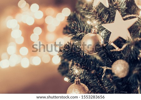 Christmas tree with decor on blurred lights background.