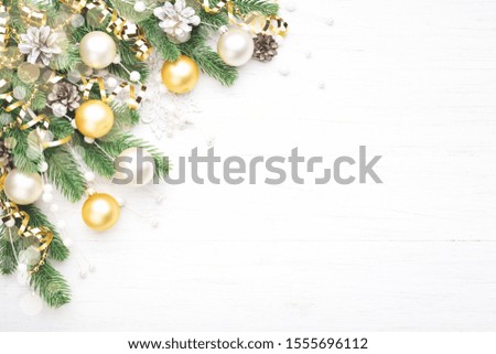 Classic Christmas composition with fir branches, white and golden baubles, golden serpentine and pine cones on white wooden background. Noel greeting card.