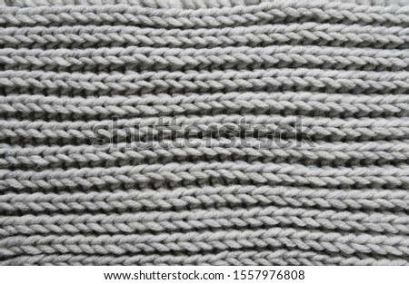 Abstract knitting fabric background. Gray texture background from merino knitted blanket, scandinavian minimalism backdrop with copy space, top view.