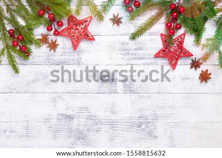 Christmas background with fir tree, holly and decoration on woodeen table. Light bokeh. Top view Copy space - Image