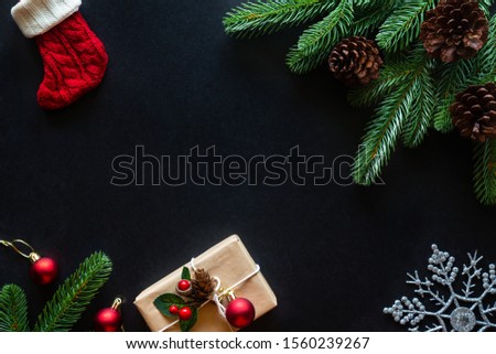 Holiday Christmas card background with festive decoration ball, stars, snowflakes, gift box, pine cones on a black background from Flat lay, top view. Space for text Merry Christmas and happy New Year