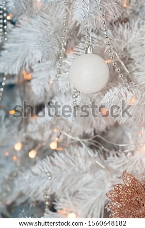 Beautiful white Christmas tree decorated with silver balls, garlands and beads. 