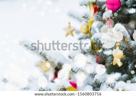Christmas tree in snow background. New Year composition with fir tree, balls and lights and bokeh.
Christmas and New Year festive background.