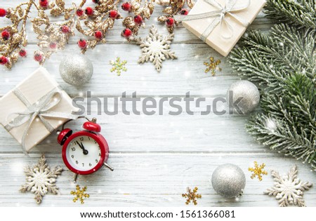 Flat lay composition with alarm clock, pine branches  and Christmas decorations on white wooden background.