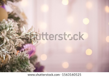 Background from a Christmas tree decorated in blue and purple close-up. Greeting card from a Christmas tree with purple decorations and copy space.