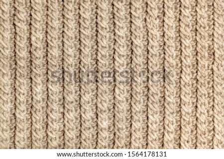 Knit texture of beige wool knitted fabric with cable pattern as background