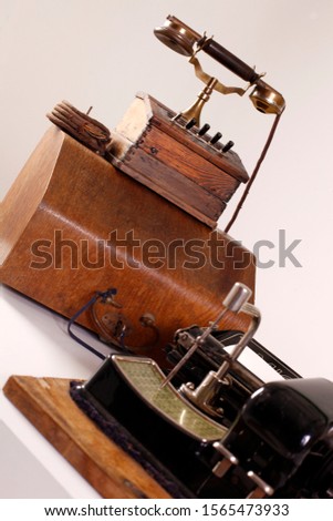 Image of antique telephone, oil lamp and typewriter on table