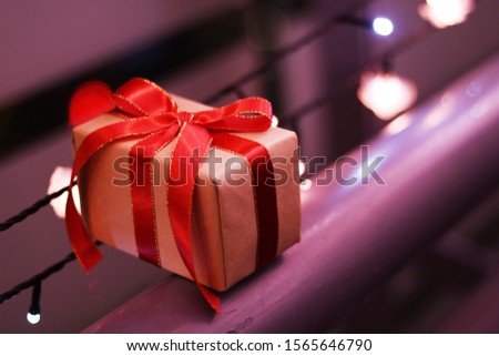 Gift box wrapped  with red ribbon, glittery and bokeh background, copy space.