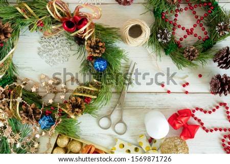 Christmas wreath with cones, ribbons, and Golden nuts on a wooden background. Flat position style. Holiday decoration. The concept of creating decor.