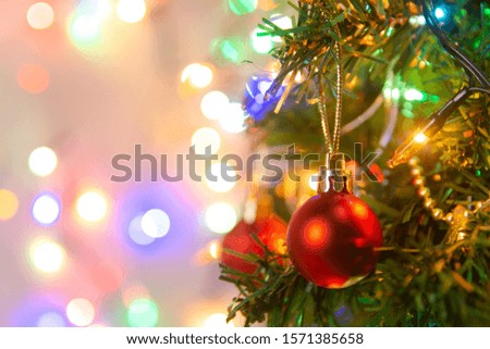 Christmas decoration. Hanging red balls on pine branches Christmas tree garland and ornaments over abstract bokeh background with copy space

