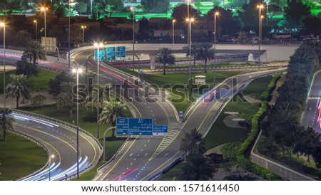 Aerial top view to junction on Sheikh Zayed road near Dubai Marina and JLT night timelapse, Dubai. Traffic, street lights and palms. United Arab Emirates