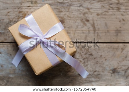 Cardboard decoration for christmas. Holiday box with rustic brown background. Gift box on wooden background. Surprise package for new year holidays. Craft gift concept. Background with a vintage feel.