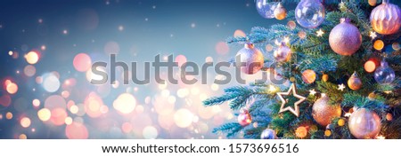 Christmas Tree With Golden Baubles And Shiny Lights In Blue Background
