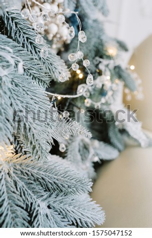 Decorative silver toy on tree with sparkling lights. Selective focus. Festive background.