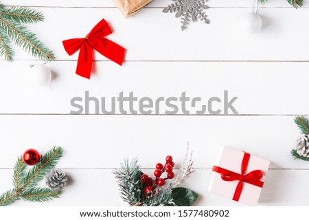 Beautiful Christmas composition on wooden white background with Christmas gift boxes, snowy fir branches, conifer cones, holiday decoration, caramel stick. New Year. Top view, copy space.