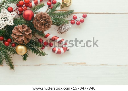 White wood with pine leaf, pine cones or conifer cone, holly balls, star, candy cane and bauble in Christmas concept. Wood plank background in top view flat lay with copy space for Christmas wallpaper