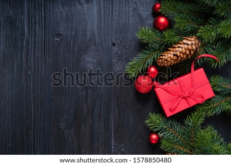 Christmas flat lay scene with red present boxes and green twigs, Christmas celebration and gift giving concept, copy space on wooden background