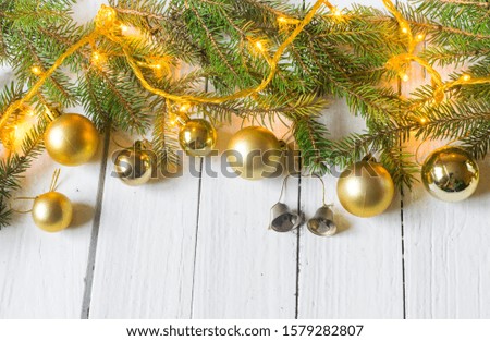 Beautiful christmas decoration (baubles, lights, pine branches) on old white, wooden background. Place for text included