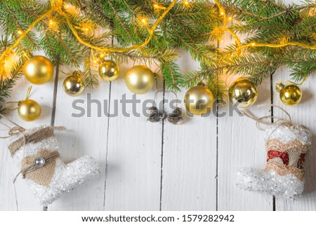 Beautiful christmas decoration (baubles, lights, pine branches) on old white, wooden background. Place for text included