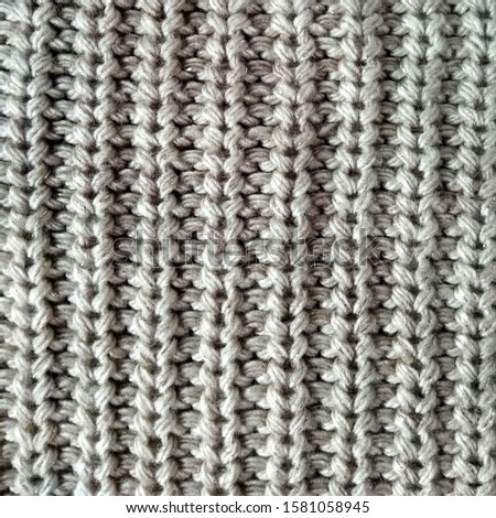 Seamless gray knitwear fabric texture. Knitting texture of sweater or scarf or plaid. Knitted grey background. Close up, top view.