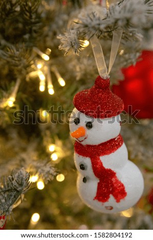 Close up of happy snowman on Christmas tree. DIY handmade decoration. Selective focus. Concept for Christmas postcard.