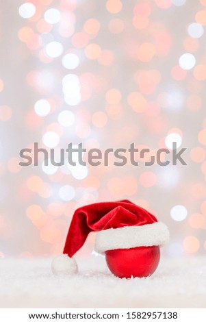 Santa hat hangs on Christmas tree toy. Festive background with copy space for your text