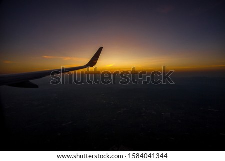 Blurred abstract background from passenger plane window Can see the sky, mountains and the morning sun, while traveling during the day