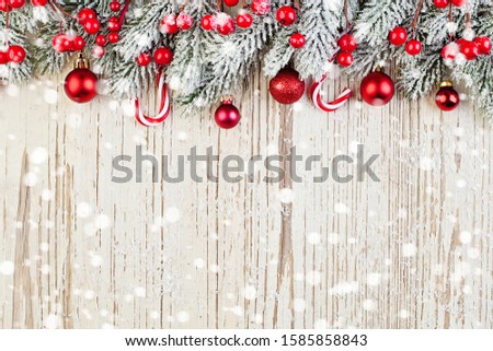 Winter card background. Red Christmas decoration on white wooden background with snow