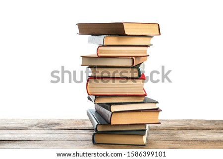 Stack of old vintage books on wooden table against white background