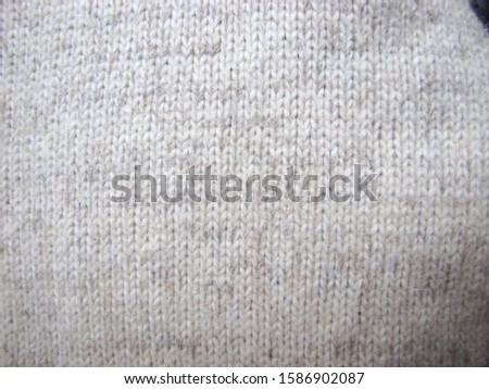 Knitted woolen background. Texture of wool close-up in shades of gray and white. Handmade.
