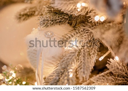 Luxurious festive decor of a Christmas tree with garlands for an elegant holiday. Background of a happy new year and the atmosphere of comfort.
