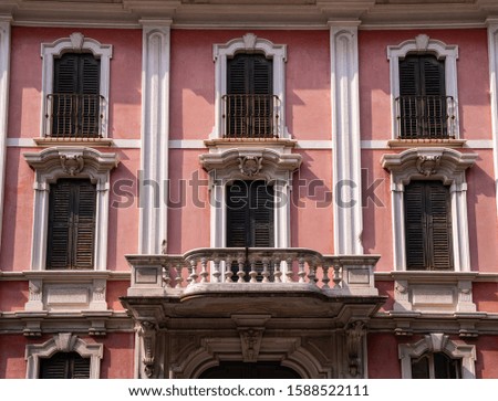 Facade of a typical residential old pink building. Italy.