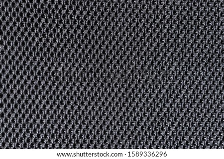 Texture of a dark mesh surface or upholstery in an office chair close up