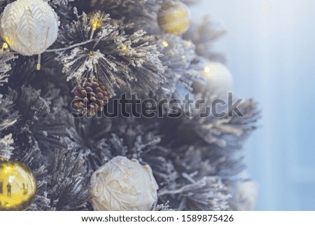 Beautiful silver and gold Christmas Bauble hanging on decorated Christmas tree festive christmas eve background concept