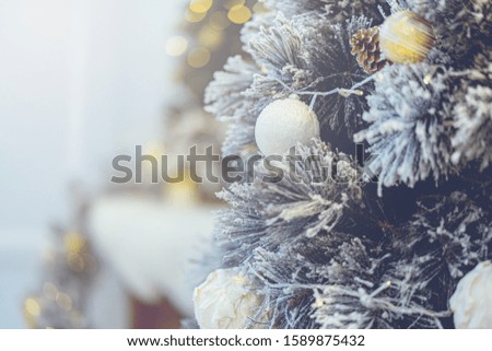 Beautiful silver and gold Christmas Bauble hanging on decorated Christmas tree festive christmas eve background concept
